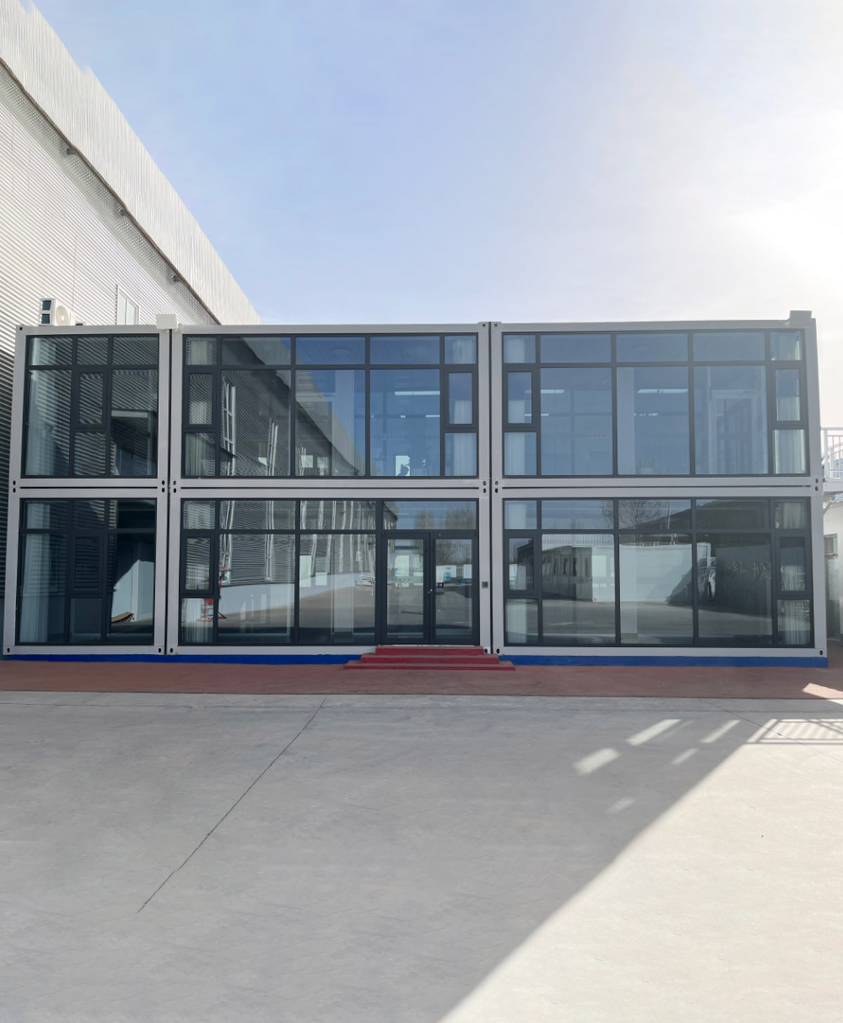 The two‑storey modular office building with glass curtain walls has been completed, creating a modern prefabricated workspace.